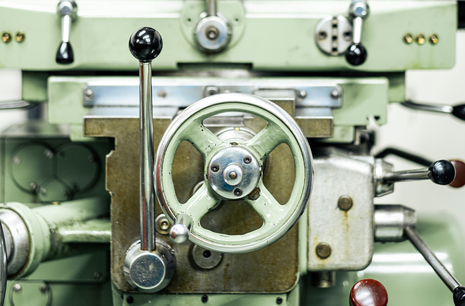 Gros plan machine décolletage traditionnelle, volant et leviers de commande